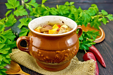 Image showing Roast meat and potatoes in pot on dark board