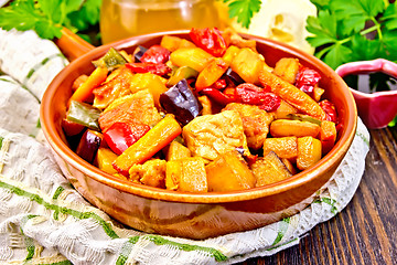 Image showing Roast with vegetables and honey in pan on dark board