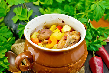 Image showing Roast meat and vegetables in pot on dark board