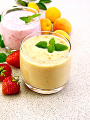 Image showing Milkshake apricot and strawberry on stone table