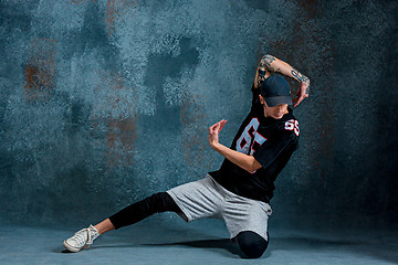 Image showing Young man break dancing on wall background.