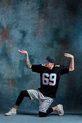 Image showing Young man break dancing on wall background.