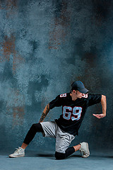 Image showing Young man break dancing on wall background.