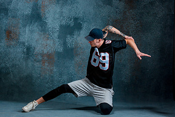 Image showing Young man break dancing on wall background.