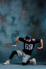 Image showing Young man break dancing on wall background.