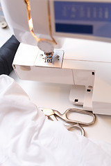 Image showing Sewing-machine with cloth on table