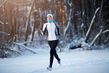 Image showing Young sportswoman running among trees