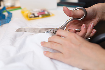 Image showing Seamstress cuts cloth pair scissors