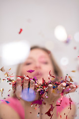 Image showing woman blowing confetti in the air