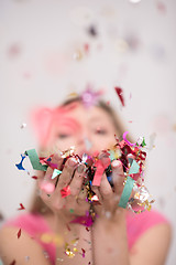 Image showing woman blowing confetti in the air