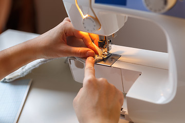 Image showing Seamstress sews fabric on machine