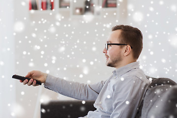 Image showing smiling man with tv remote control at home