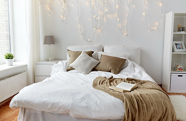 Image showing bedroom with bed and christmas garland at home