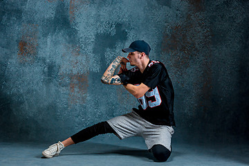 Image showing Young man break dancing on wall background.