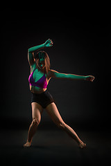 Image showing Young beautiful dancer in beige dress dancing on black background