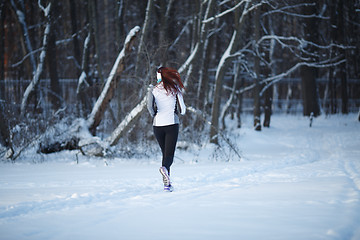 Image showing Young woman running among trees