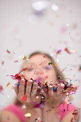 Image showing woman blowing confetti in the air