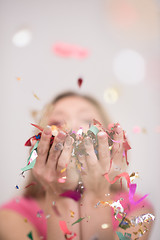 Image showing woman blowing confetti in the air