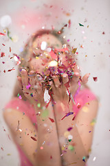 Image showing woman blowing confetti in the air