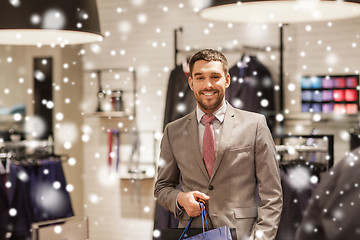 Image showing happy man with shopping bags at clothing store