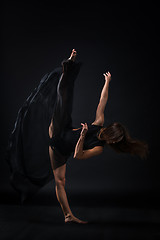 Image showing Young beautiful dancer in beige dress dancing on black background