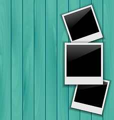 Image showing Three blank photo frames on wooden background