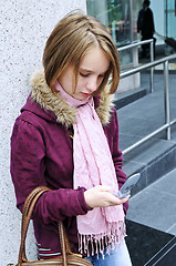 Image showing Teenage girl text messaging on cell phone