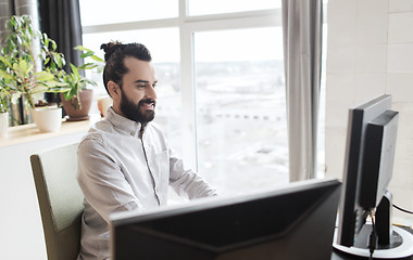 Image showing happy creative male office worker with computer