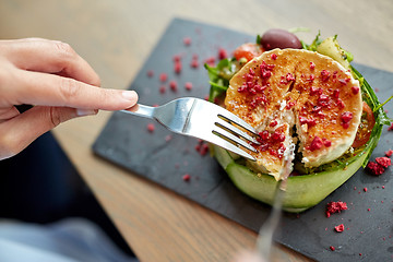 Image showing woman eating goat cheese salad at restaurant