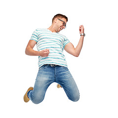 Image showing happy man jumping and playing imaginary guitar