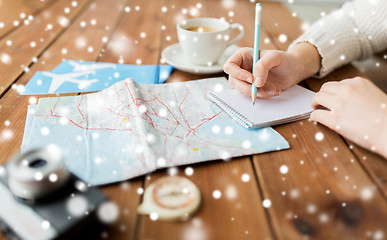 Image showing hands with map and coffee writing to notebook