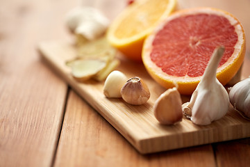 Image showing garlic, grapefruit, ginger, and orange on board