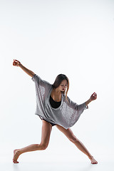 Image showing Young beautiful dancer in beige dress dancing on white background