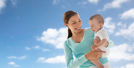 Image showing happy young mother with little baby over blue sky