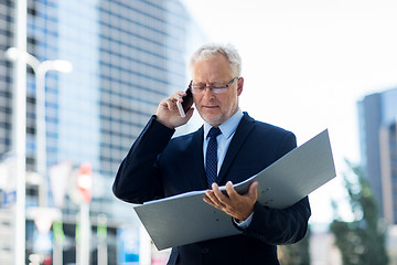 Image showing senior businessman calling on smartphone in city