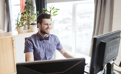 Image showing happy creative male office worker with computer