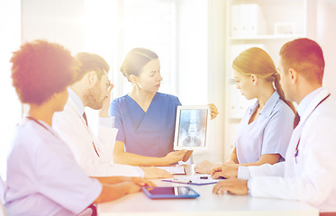 Image showing group of doctors with x-ray on tablet pc at clinic