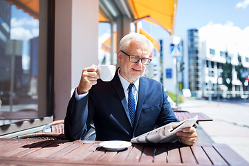 Image showing senior businessman with newspaper drinking coffee