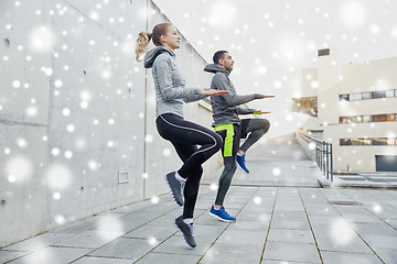 Image showing happy man and woman jumping outdoors