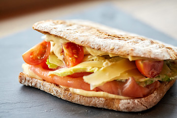 Image showing salmon panini sandwich on stone plate