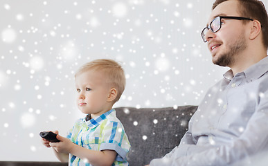 Image showing father and son with remote watching tv at home