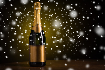 Image showing bottle of champagne with golden label over snow