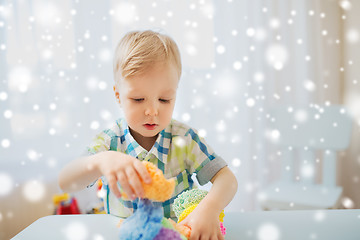 Image showing happy little baby boy with ball clay at home