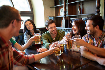 Image showing happy friends drinking beer at bar or pub