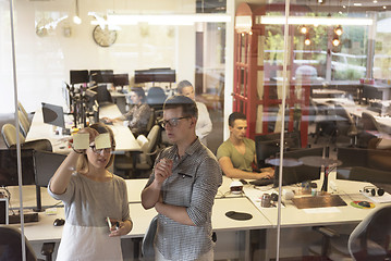 Image showing young couple at modern office interior writing notes on stickers