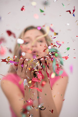 Image showing woman blowing confetti in the air