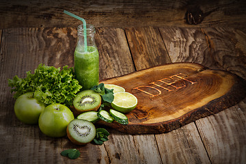 Image showing The bottles with fresh vegetable juices on wooden table