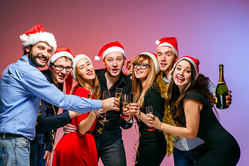 Image showing Many young women and men drinking at christmas party