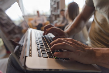 Image showing close up of male hands while working on laptop