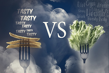 Image showing Green lettuce leaves and French fries on a fork